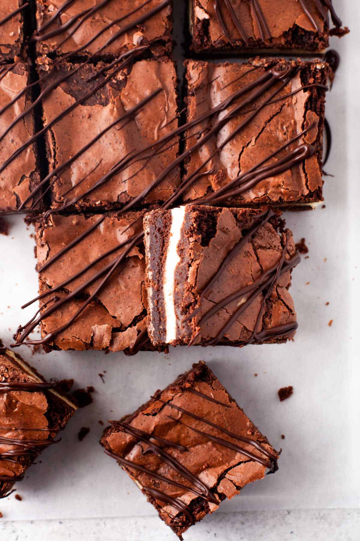 A sideways frozen cheesecake brownie leaning against more brownies. 