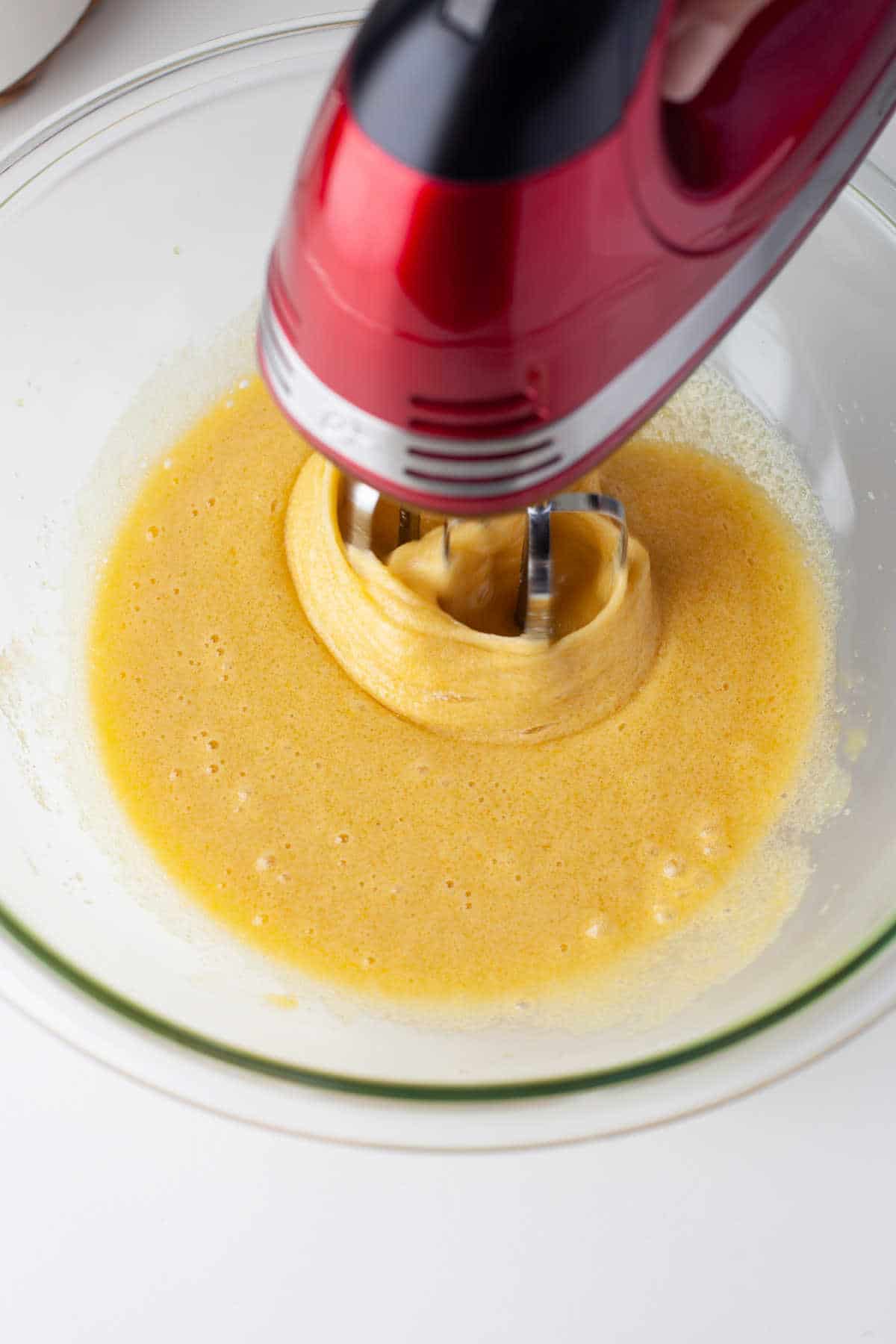 An electric mixer beating egg mixture. 