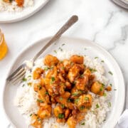 A plate of honey garlic chicken over rice.