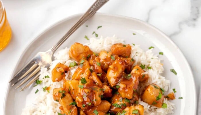 A plate of honey garlic chicken over rice.