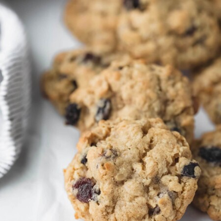 Oatmeal raisin cookies next to a striped kitchen linen.