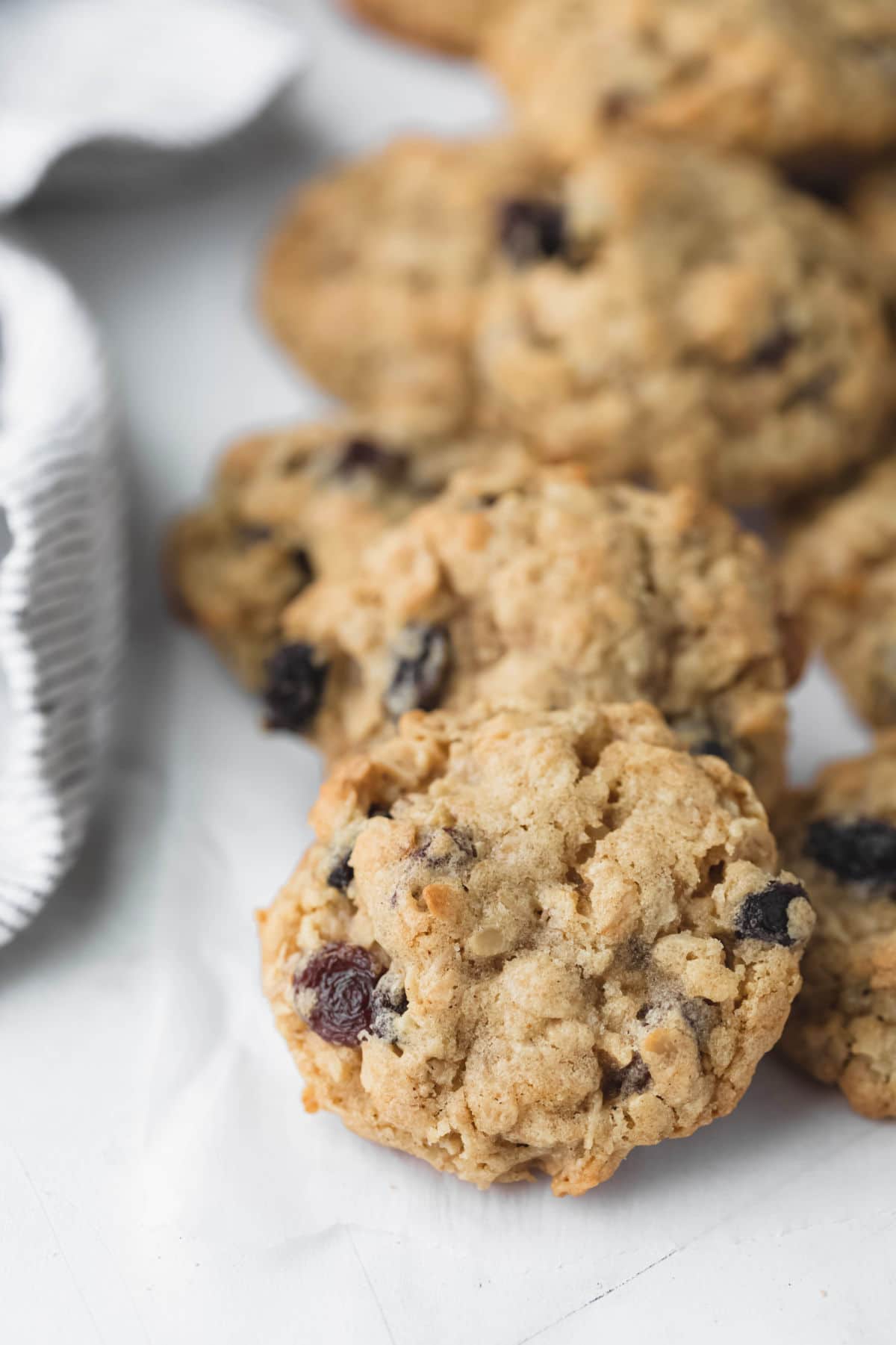 Oatmeal raisin cookies next to a striped kitchen linen.