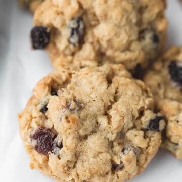 Oatmeal raisin cookies on a piece of parchment paper.