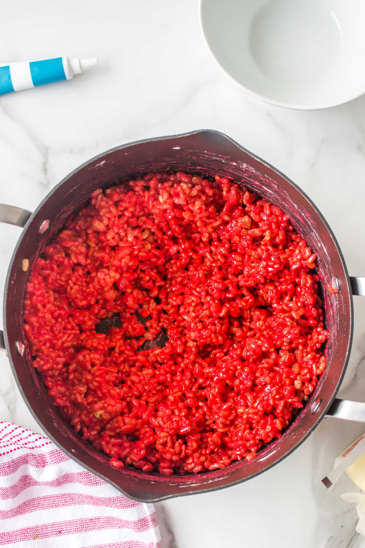 Red rice krispies in a large saucepan.