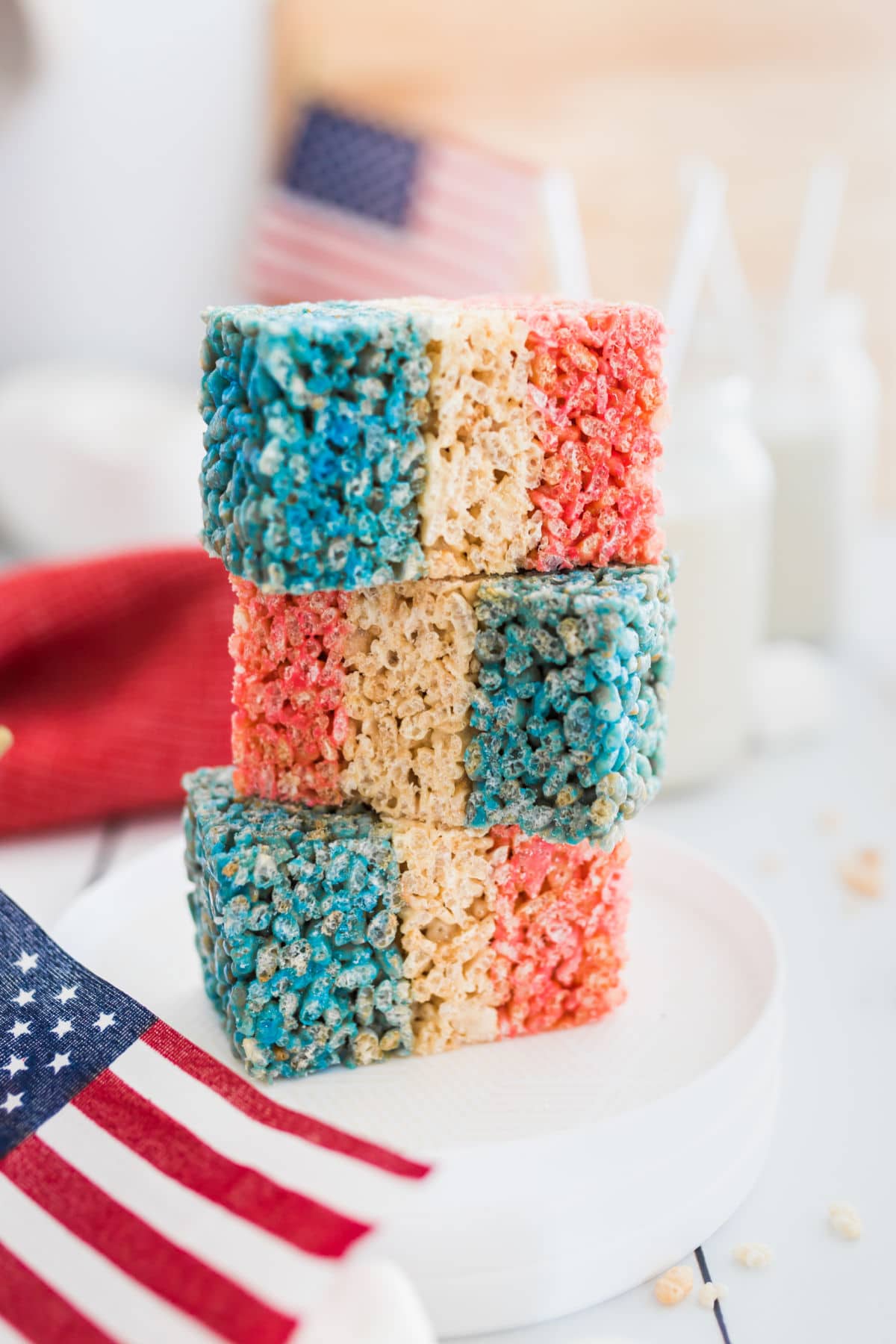 Three 4th of july rice krispies treats next to an American flag.