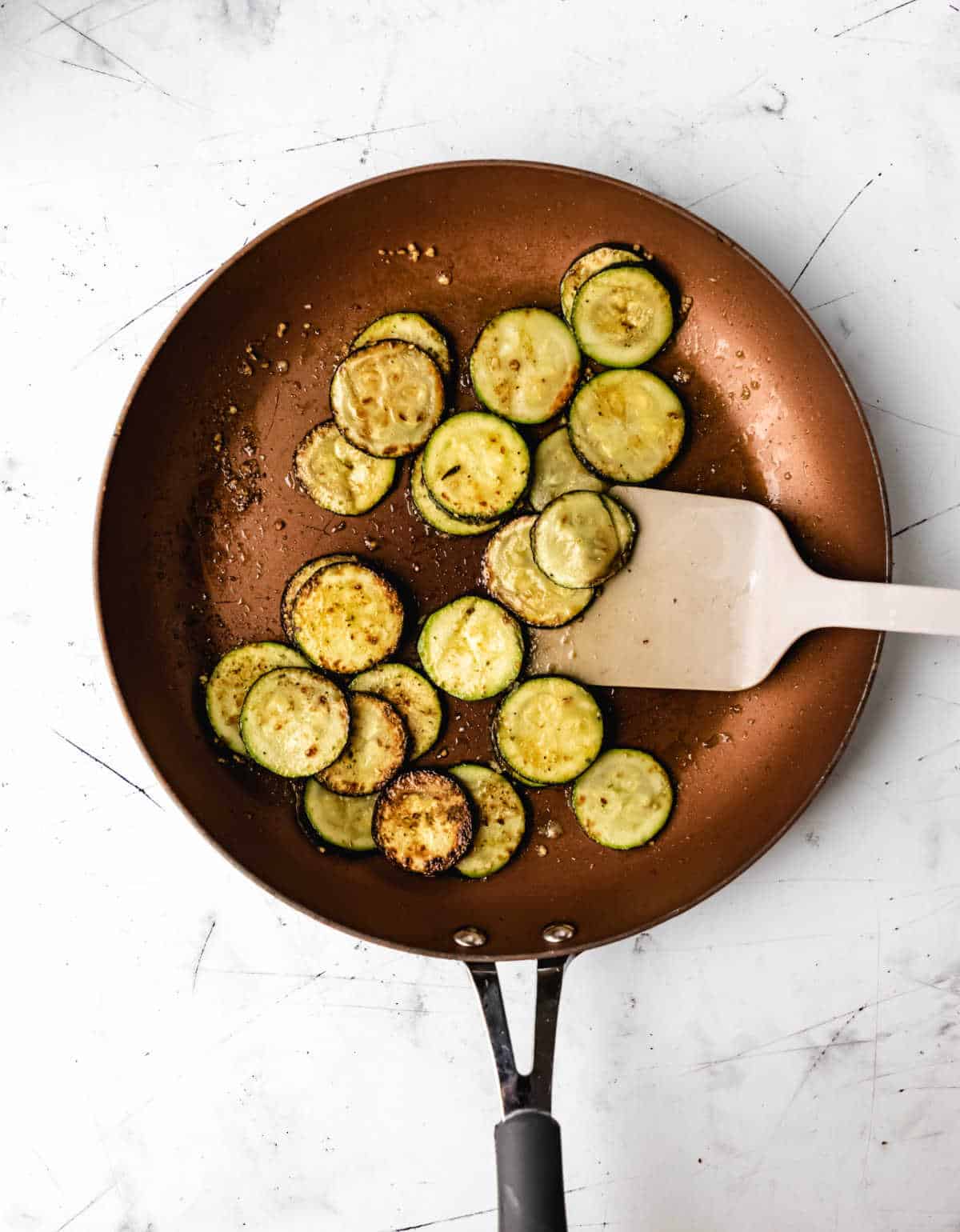 Zucchini cooking in a skillet. 