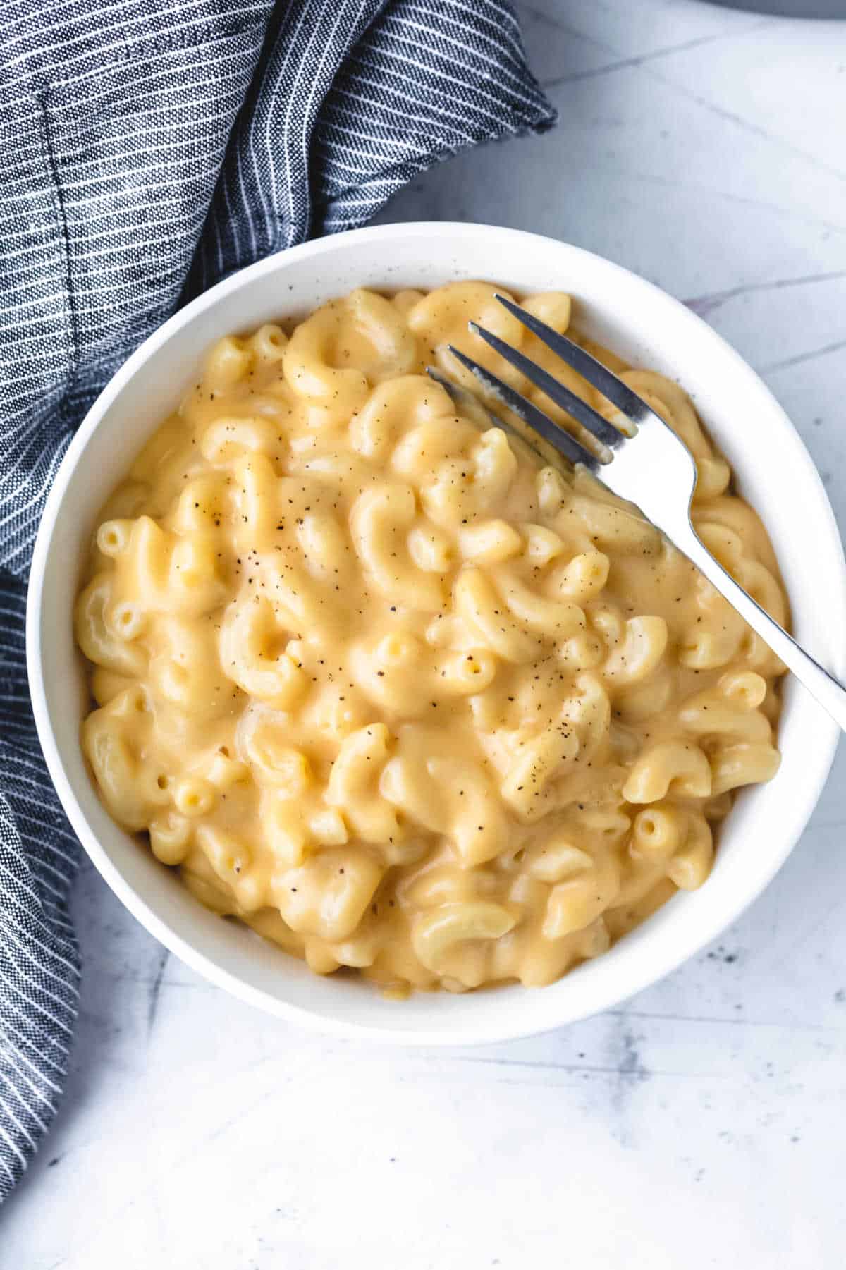 Homemade Mac and Cheese Recipe A fork in a bowl of macaroni and cheese.