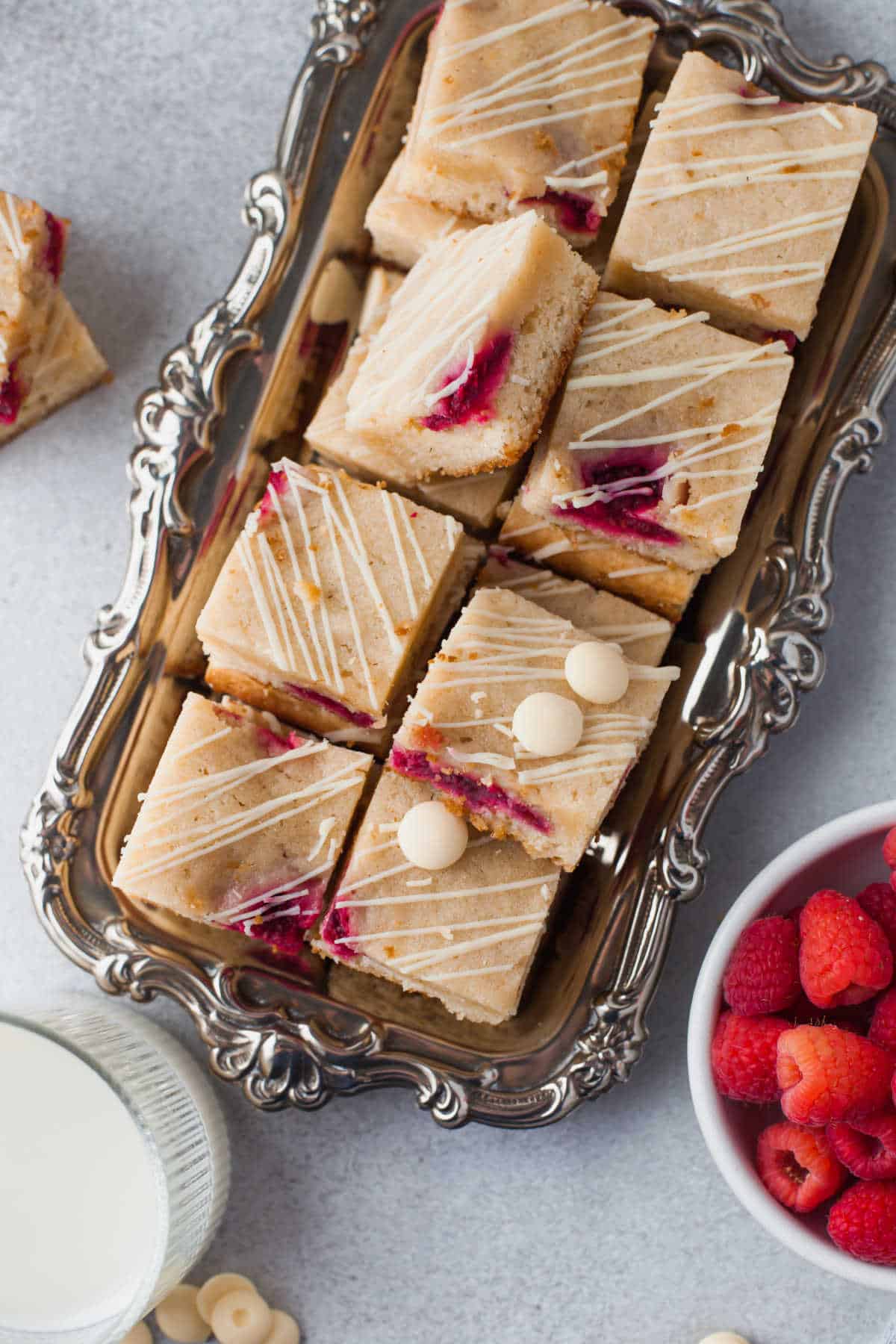 A silver dish holding white chocolate raspberry blondies. 