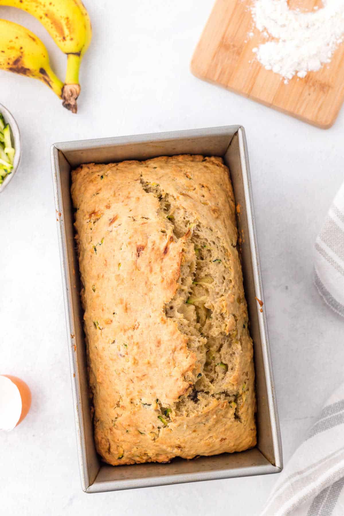 Loaf of zucchini banana bread in a loaf pan.