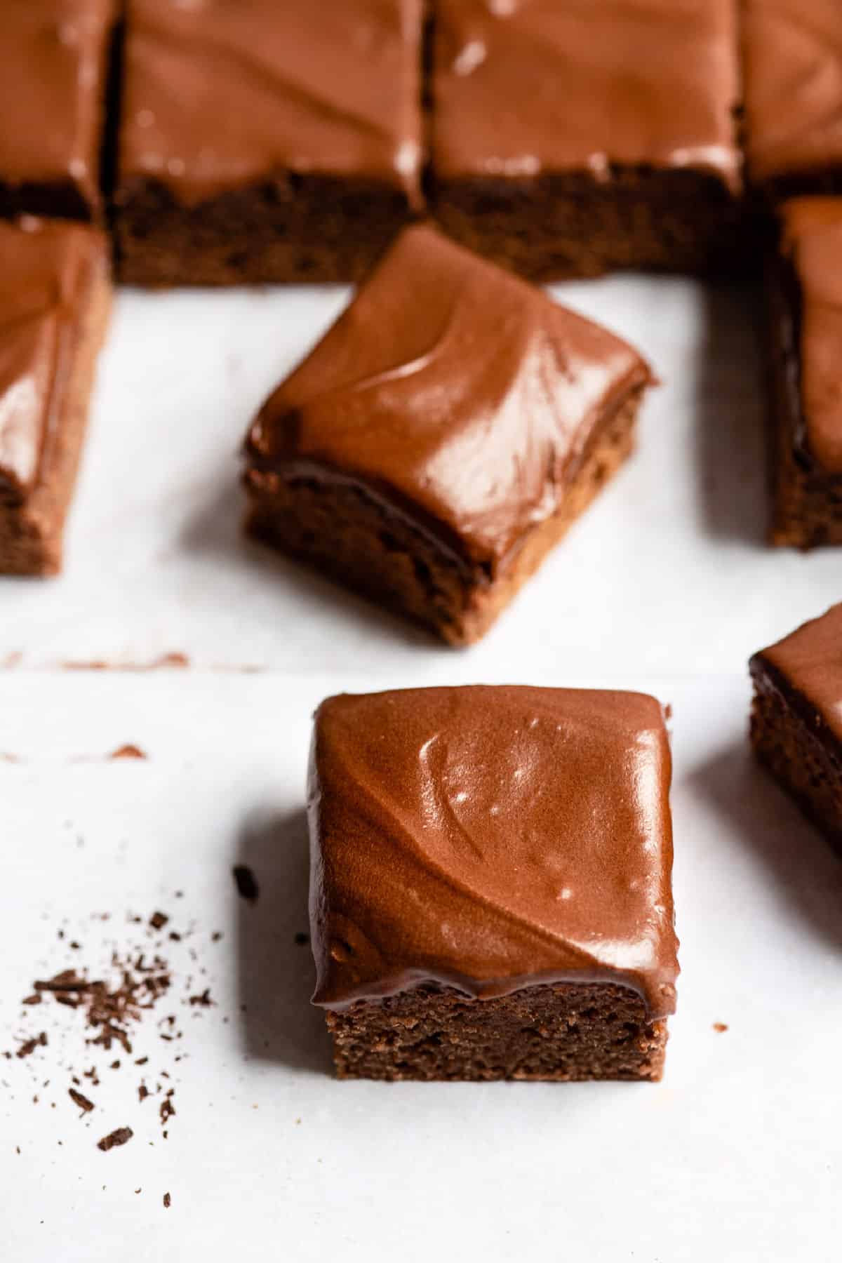 A frosted brownie next to a perpendicular brownie. 