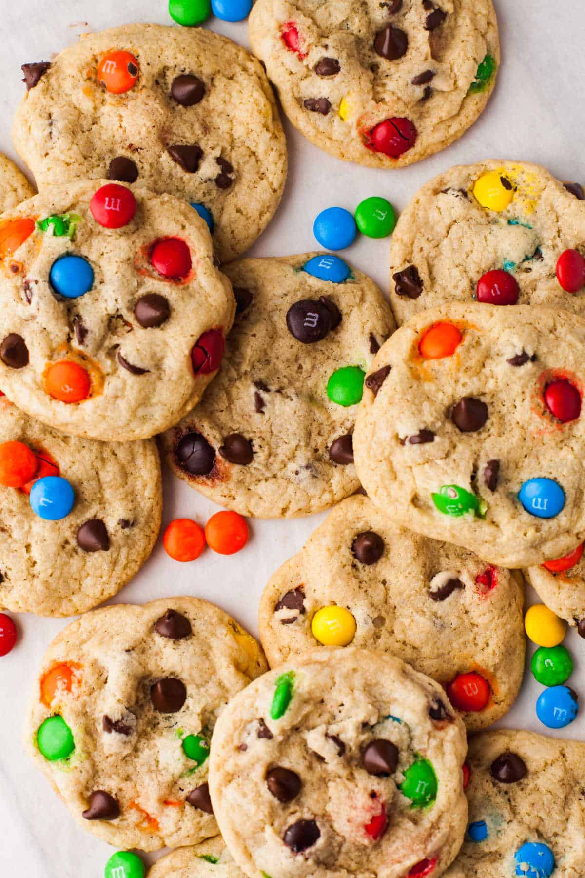 Bakery Style M&M Chocolate Chip Cookies M&M cookies on a piece of parchment paper.