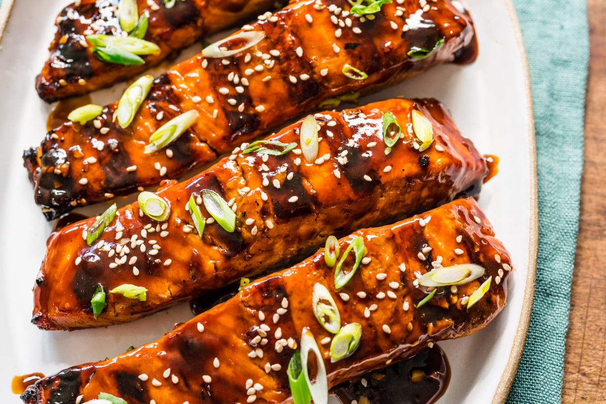Teriyaki salmon topped with sesame seeds and sliced green onions.
