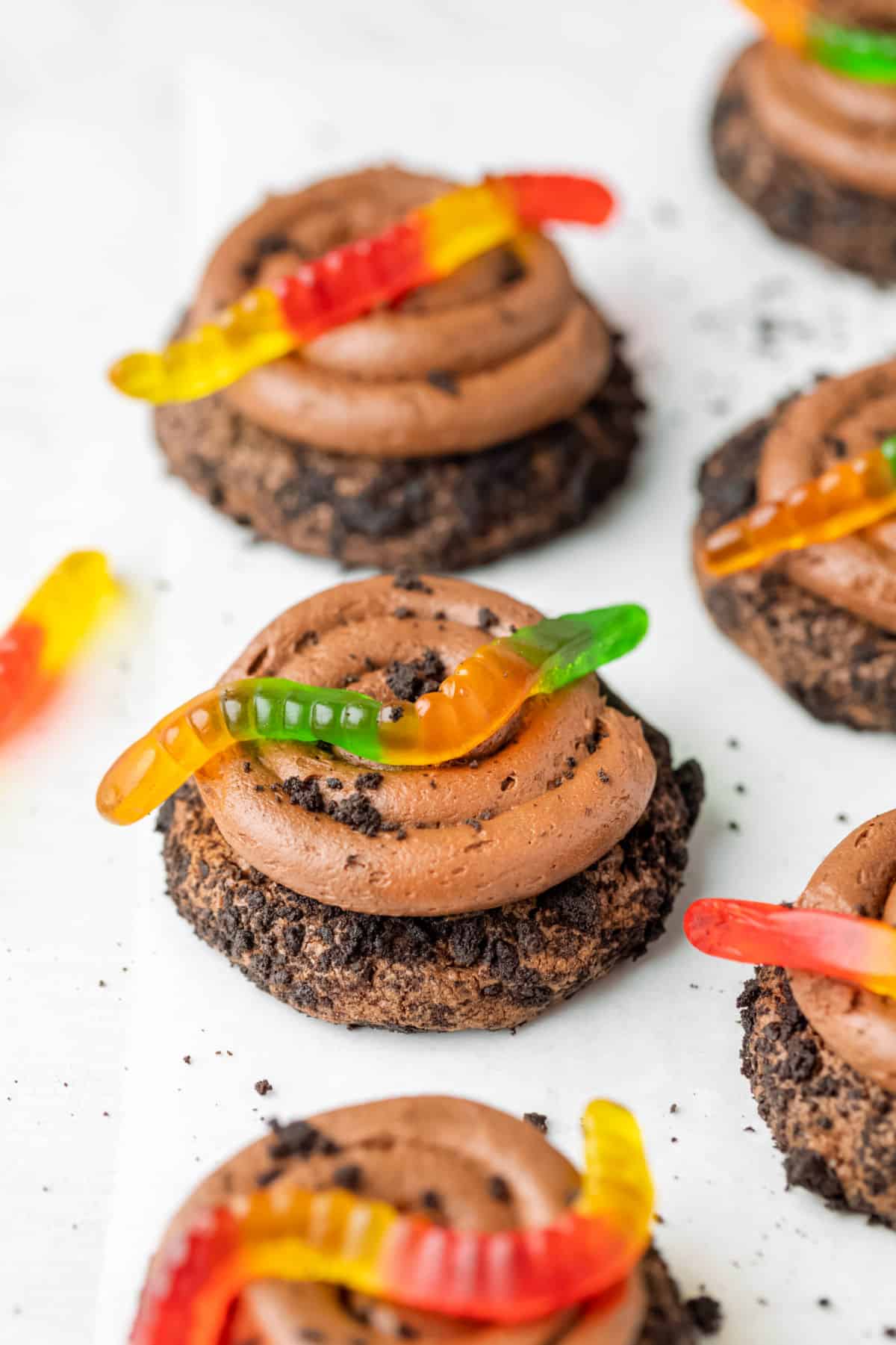 Chocolate dirt cookies topped with green and red gummy worms. 