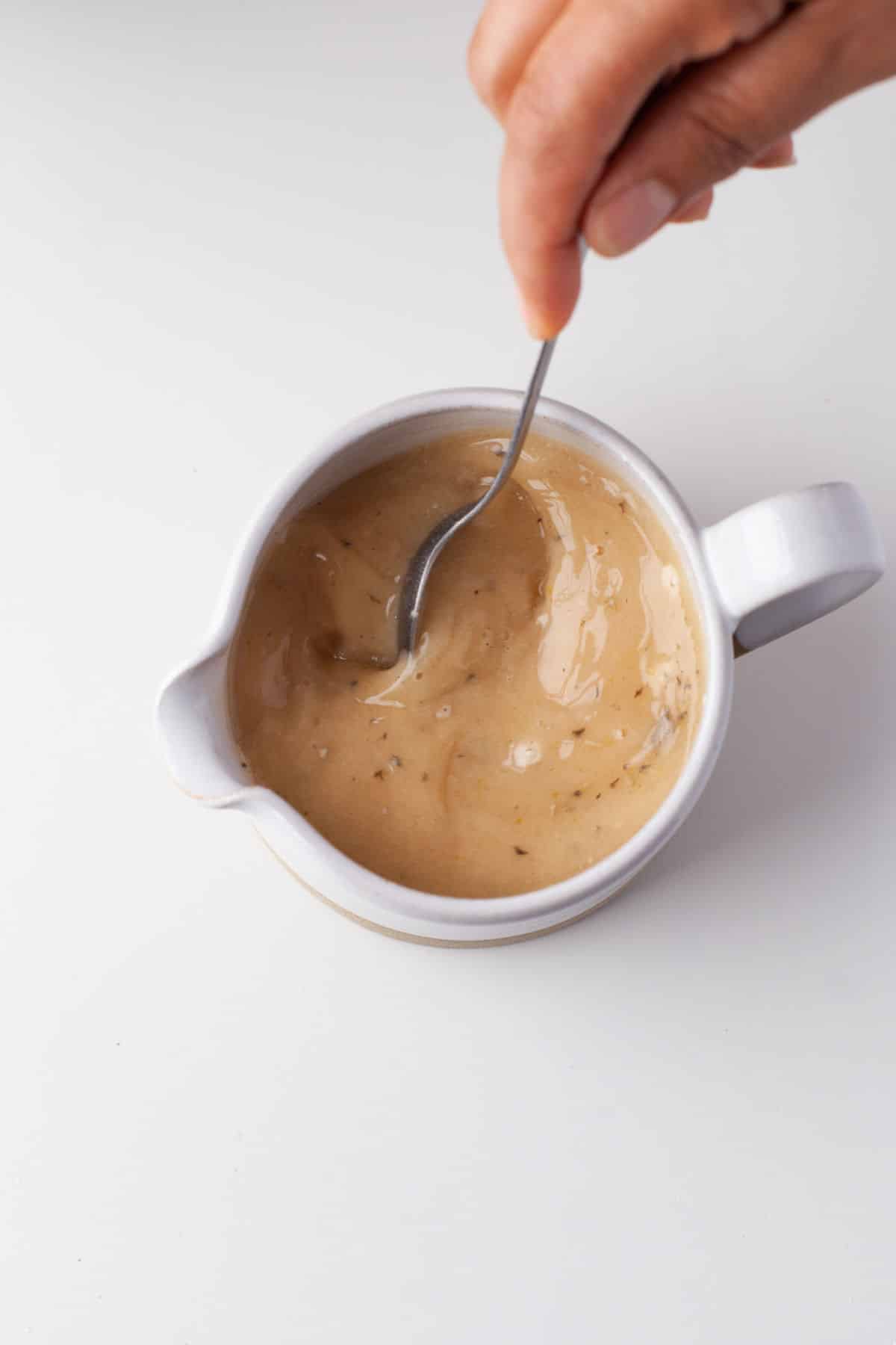 A spoon stirring Marsala wine mixture together.