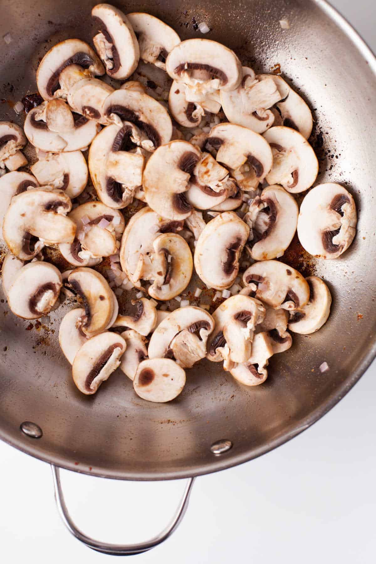 Mushrooms and shallot in a skillet.