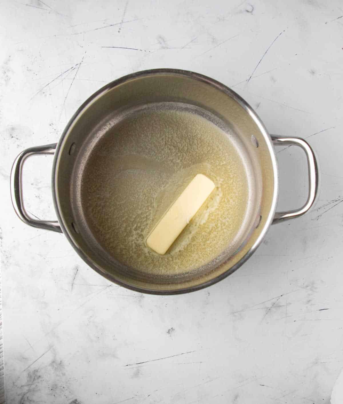 Stick of butter melting in a saucepot. 