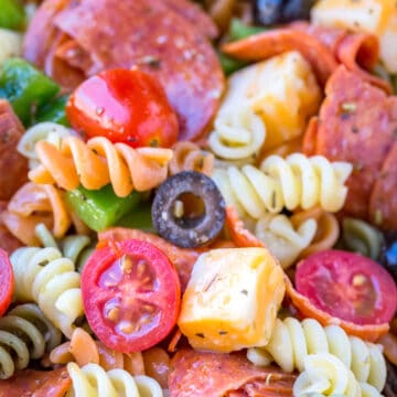 Pasta salad with pepperoni, olives, cheese, and tomatoes.