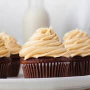 Four chocolate cupcakes topped with caramel buttercream frosting.