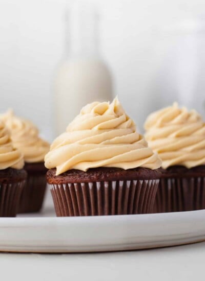 Four chocolate cupcakes topped with caramel buttercream frosting.