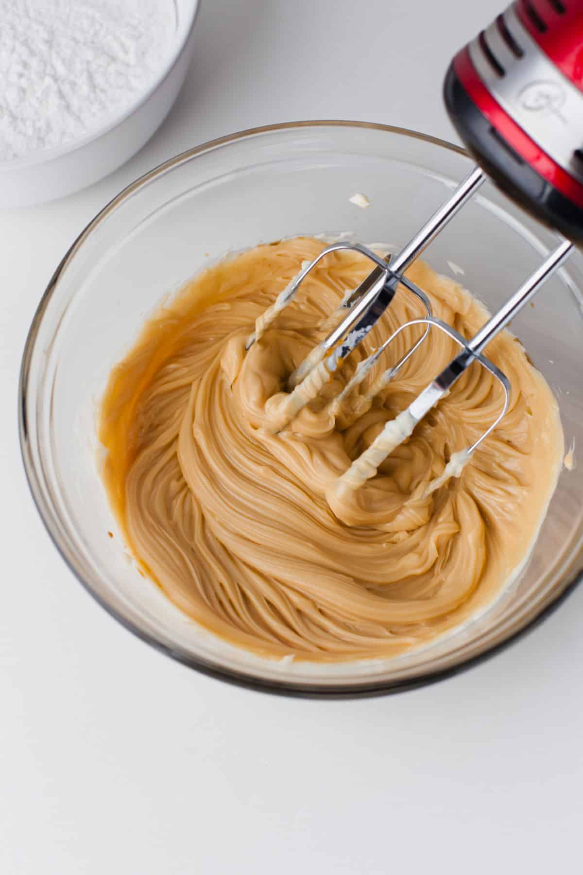 A mixer beating caramel sauce into butter. 