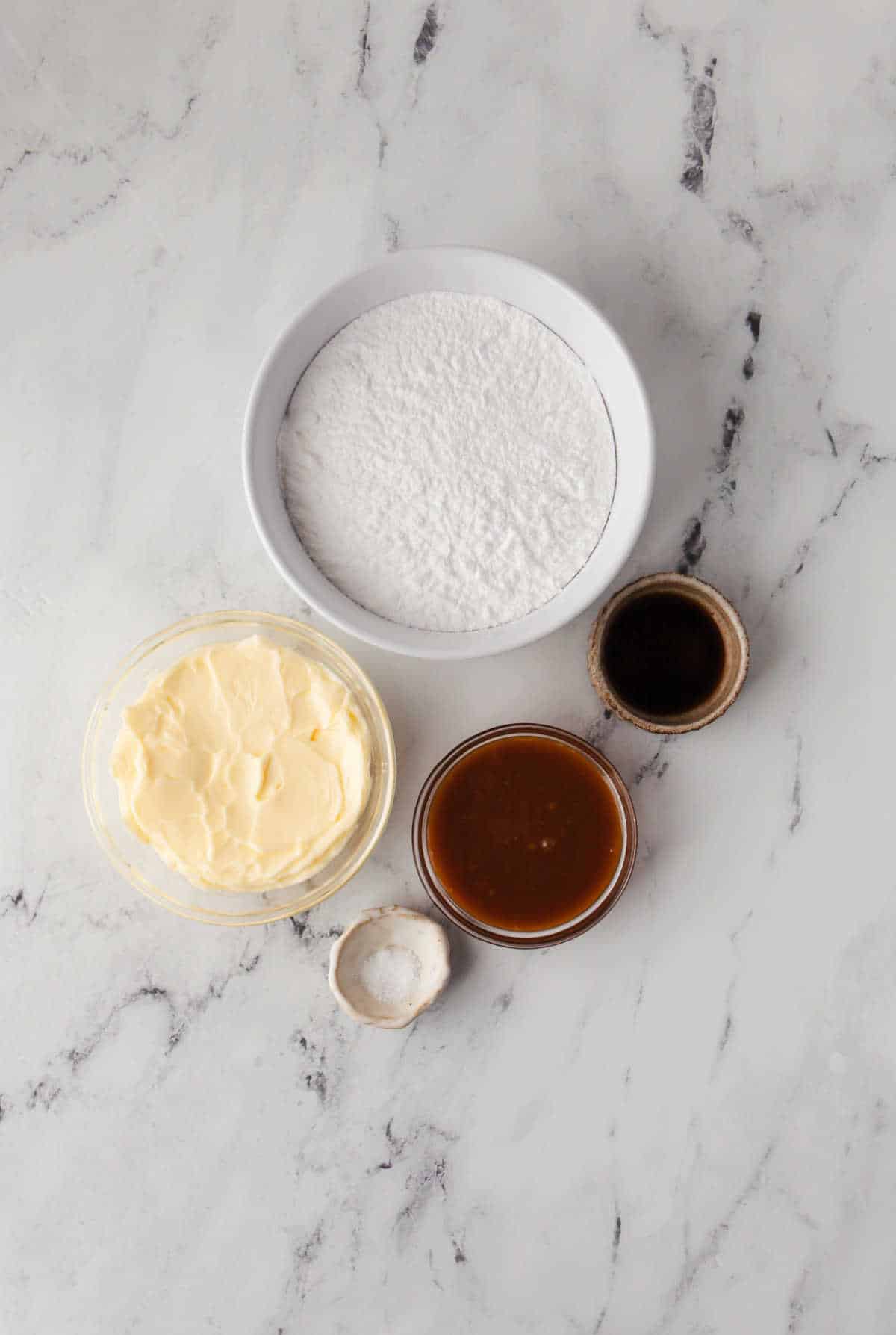 Ingredients for salted caramel buttercream frosting in dishes. 