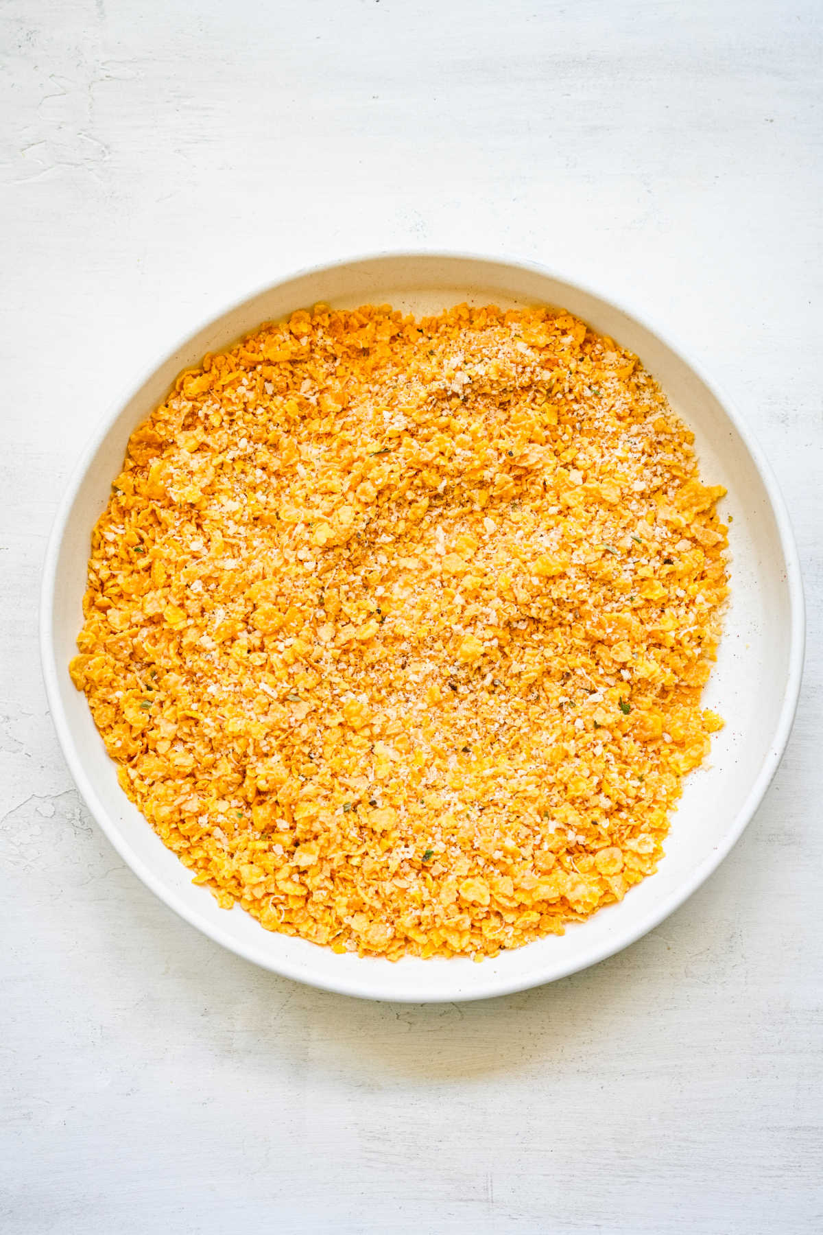 Cornflake seasoning mixture in a round shallow dish. 