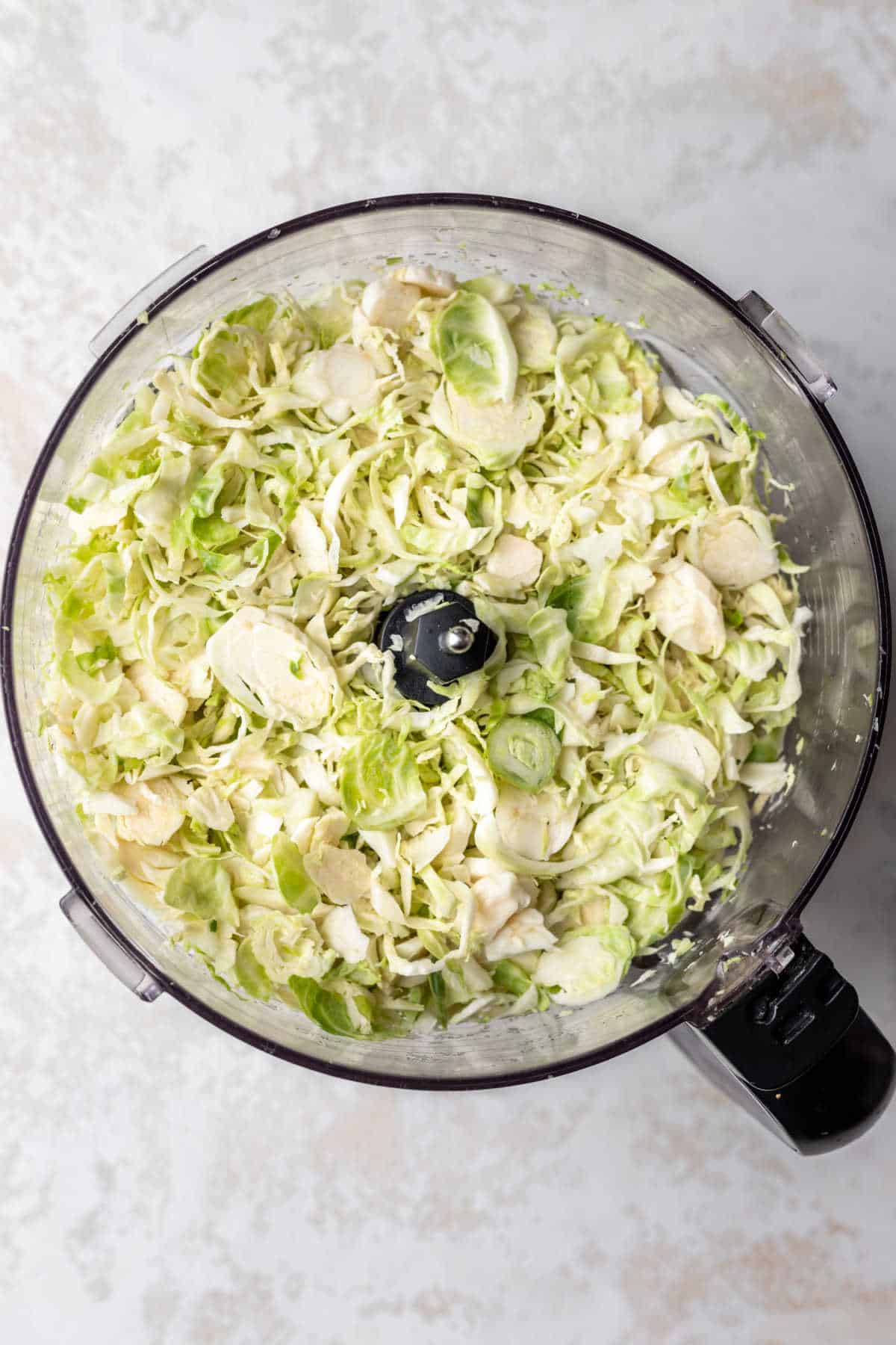 Chopped brussels sprouts in a food processor. 