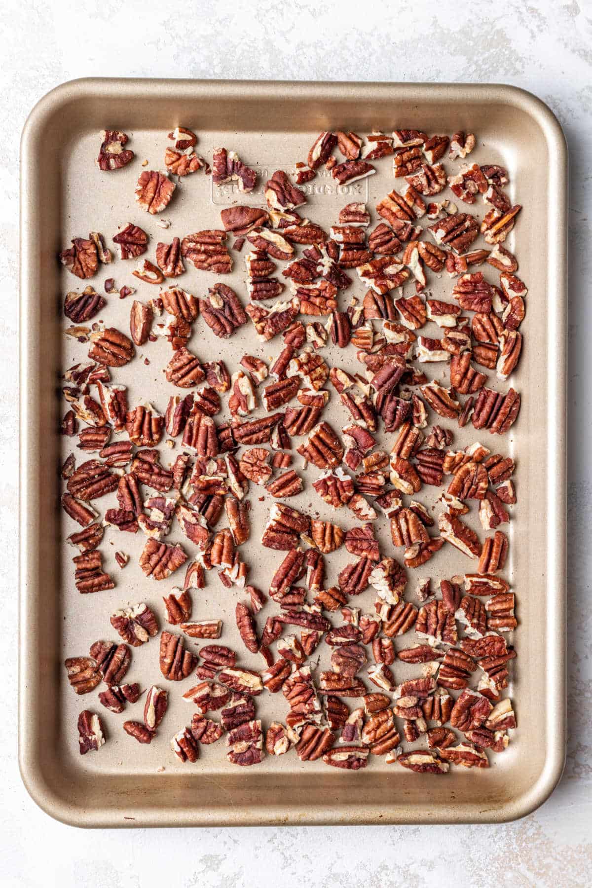 Pecans on a rimmed baking sheet. 