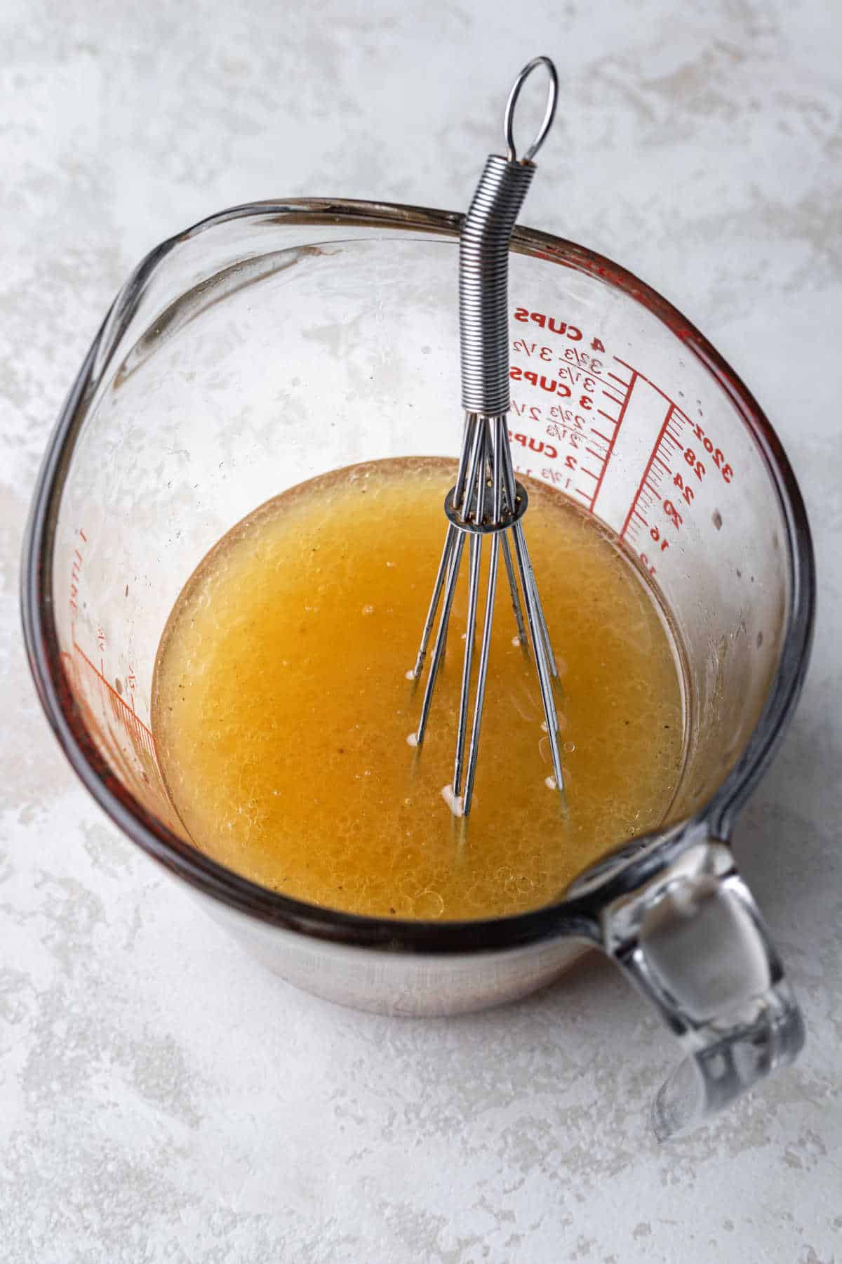 Apple cider vinaigrette in a glass measuring cup. 