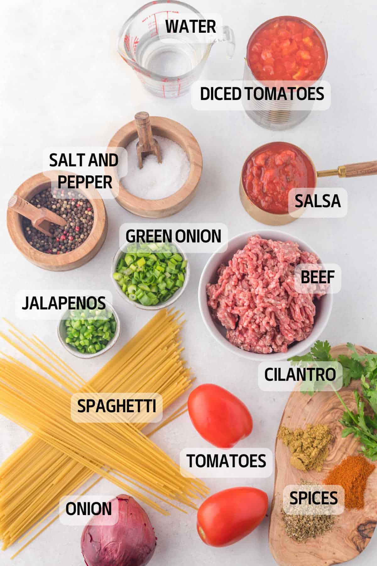 Ingredients to make taco spaghetti in dishes with labels on the photo. 