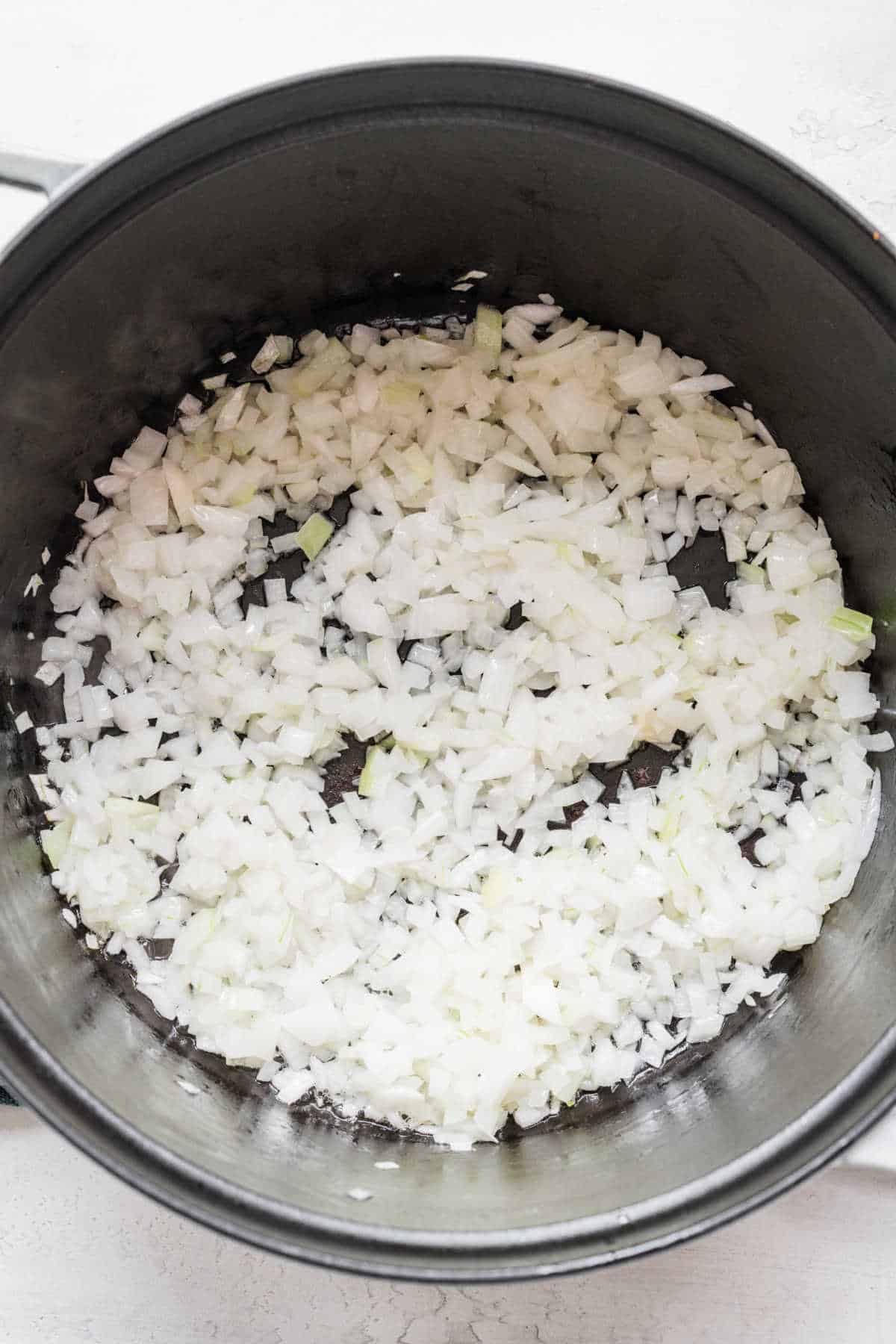 Diced onion cooking in a saucepot.