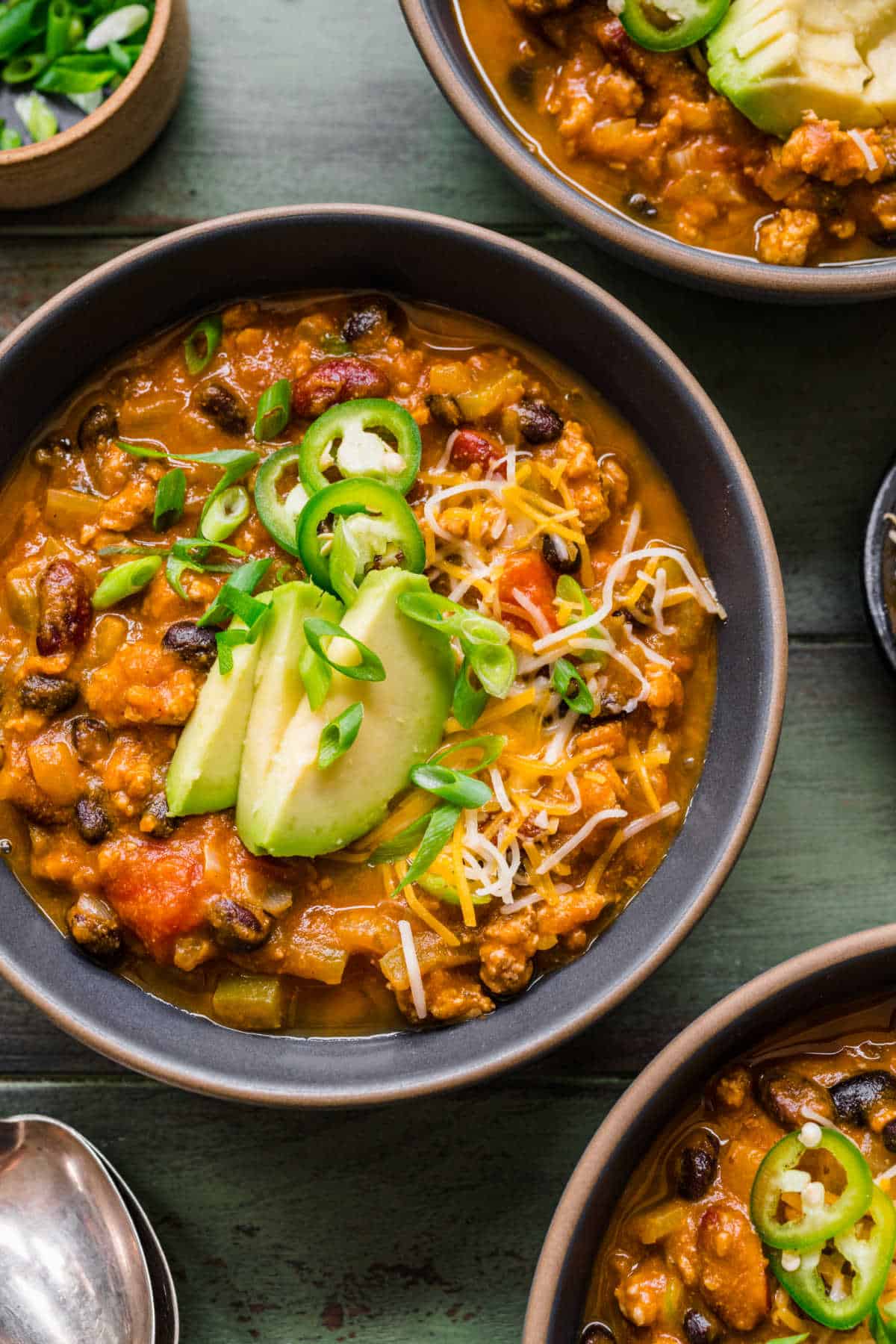 Three bowls of turkey pumpkin chili next to each other.