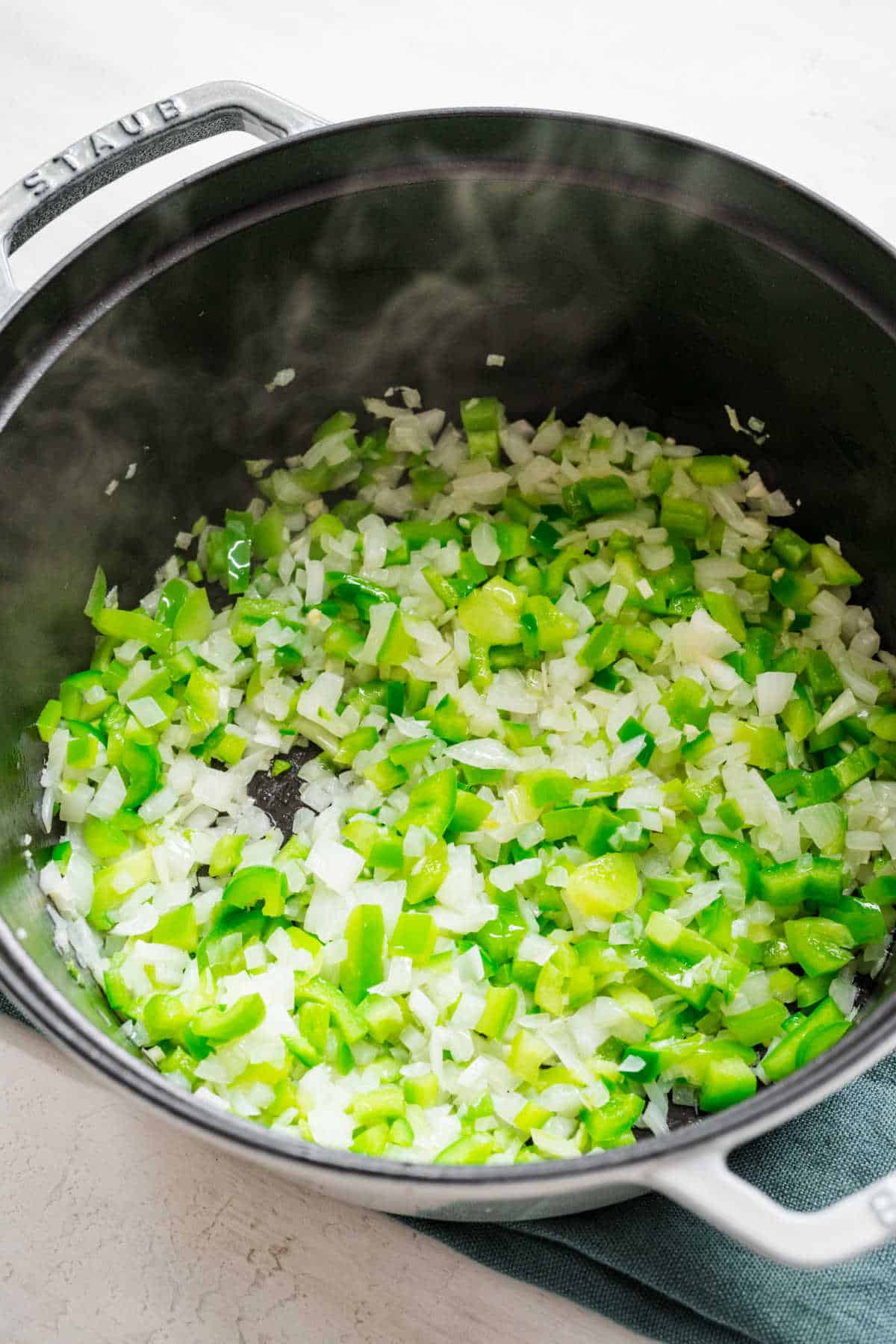 Green pepper and onion in an saucepot. 