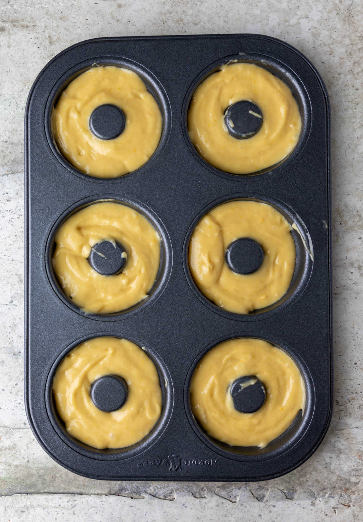 Donut batter in a doughnut pan.