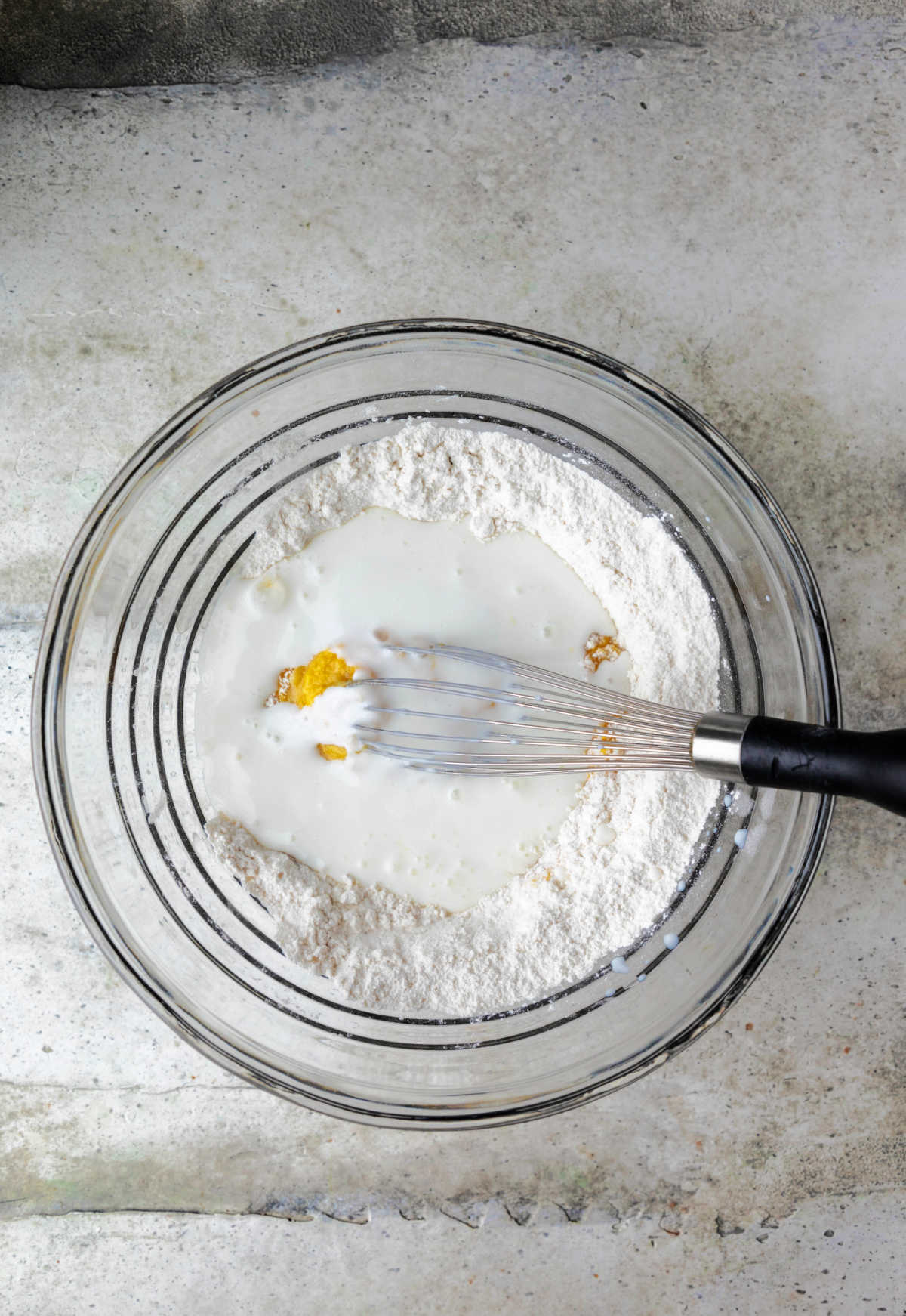 Buttermilk and eggs in a bowl of dry ingredients.
