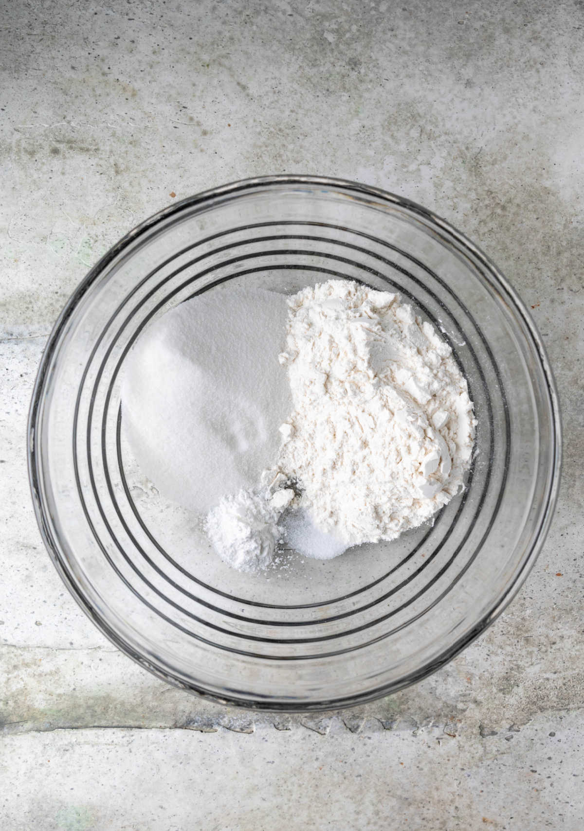 Dry ingredients on a glass mixing bowl. 