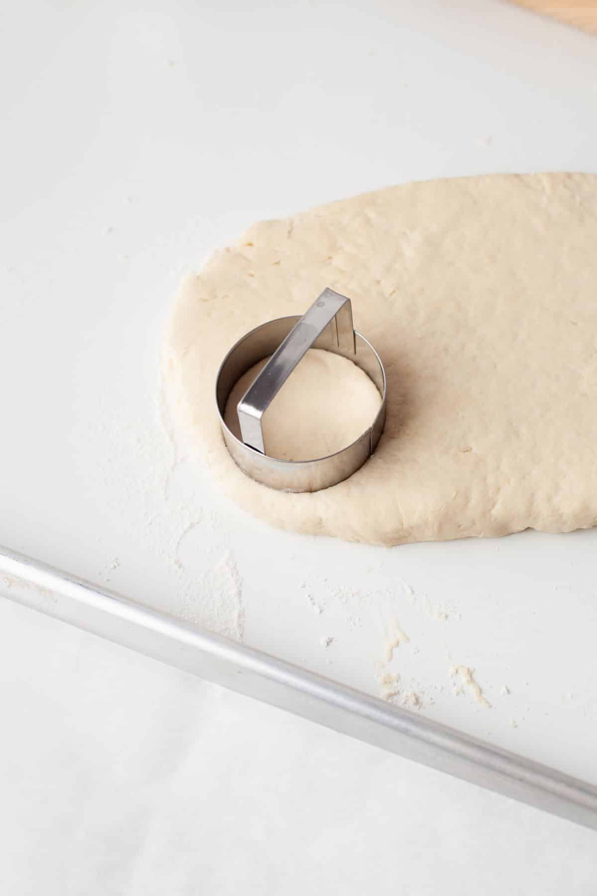 A biscuit cutter in biscuit dough. 