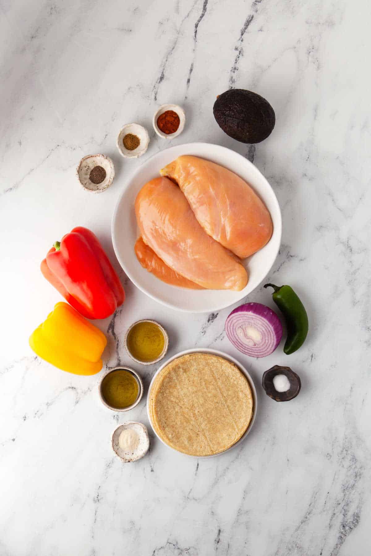 Ingredients to make chicken fajitas in dishes. 