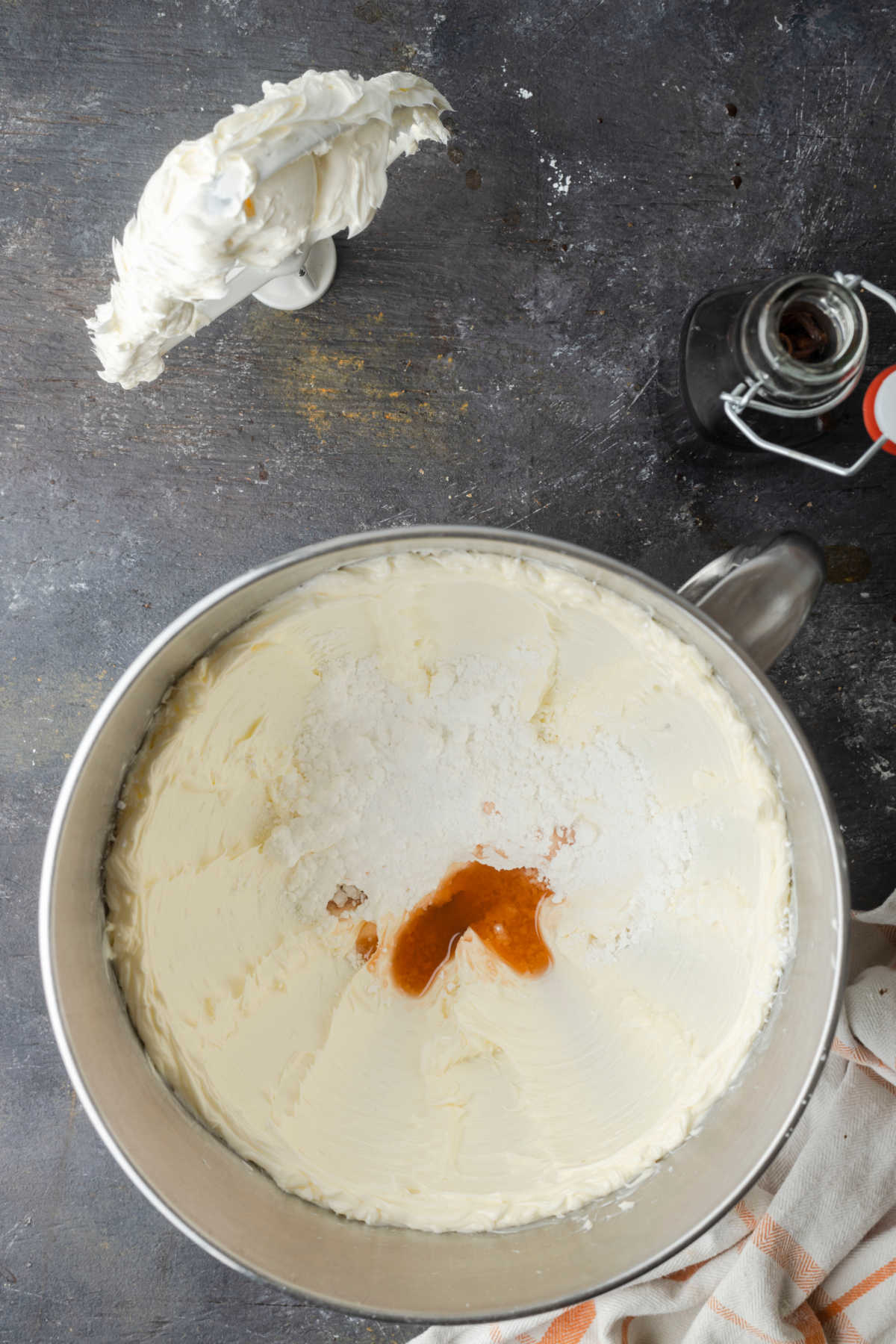 Beaten butter topped with vanilla and powdered sugar in a mixing bowl. 