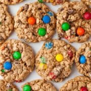 Rows of monster cookies on a piece of white parchment paper.
