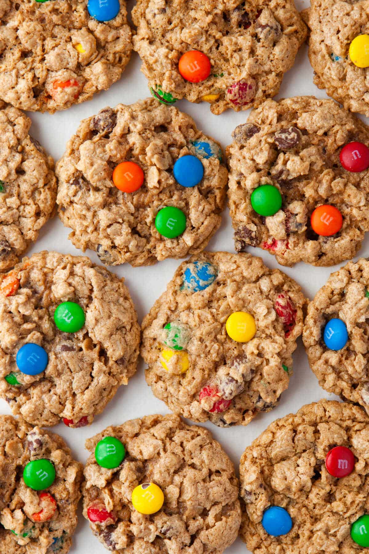 Rows of monster cookies on a piece of white parchment paper.