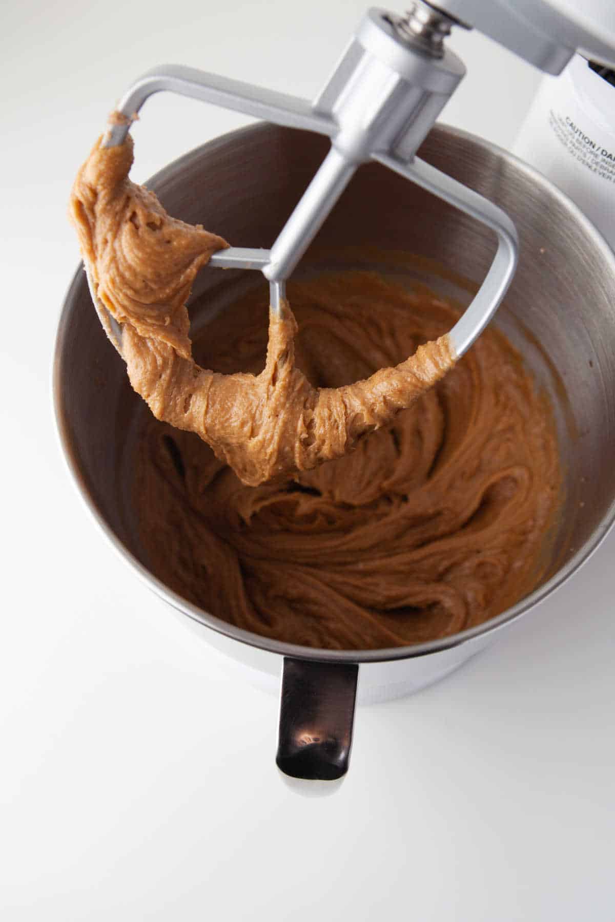 A paddle beater attachment with peanut butter egg mixture on it.
