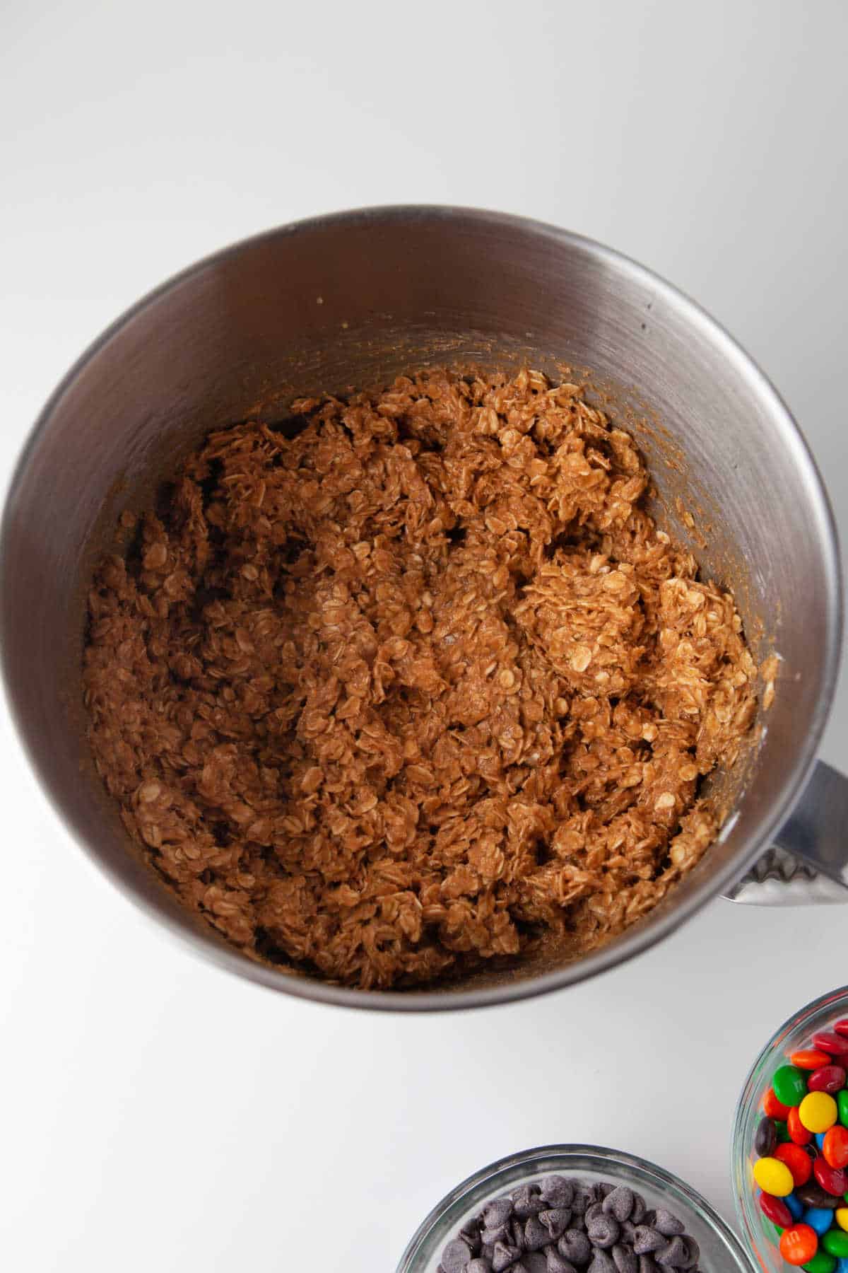 Peanut butter oatmeal cookie dough in a silver mixing bowl.