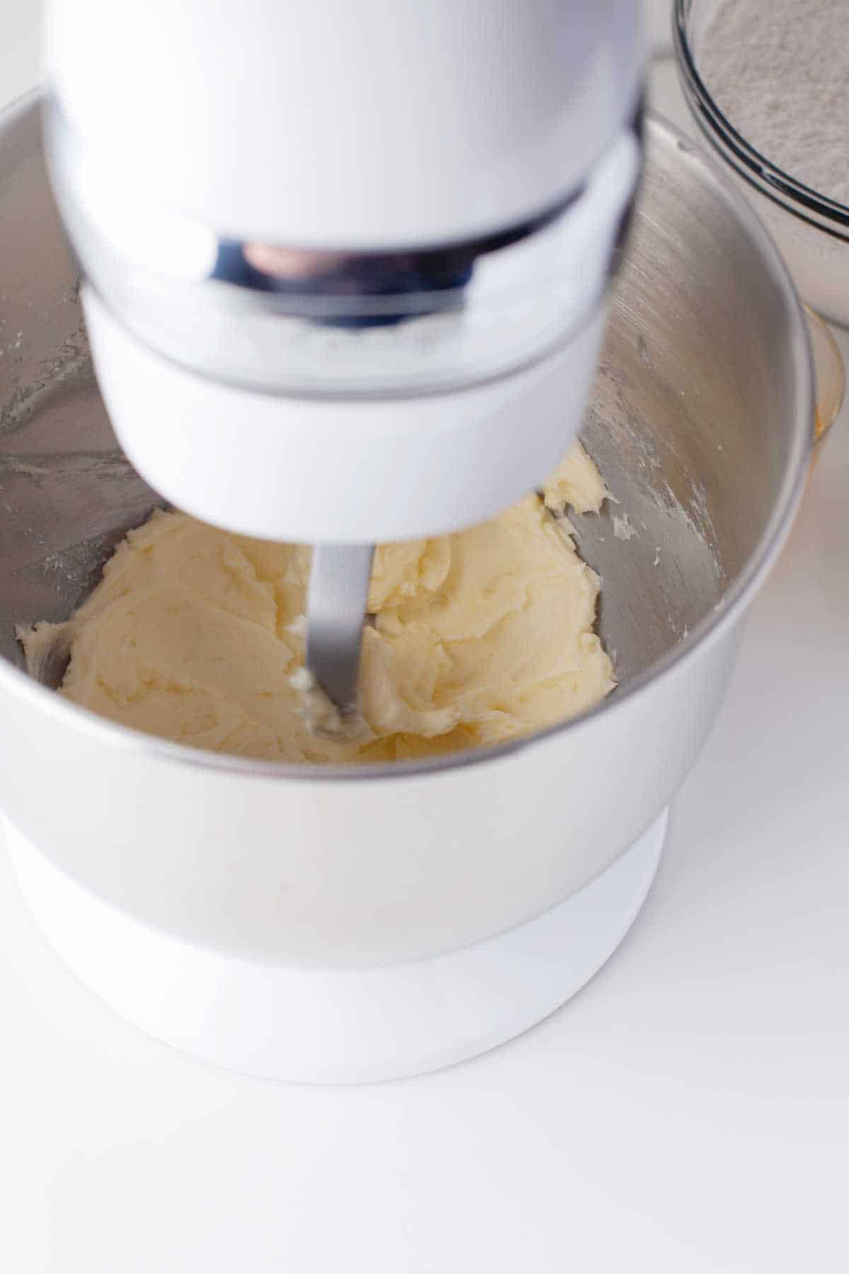 A stand mixer beating butter and sugar together. 