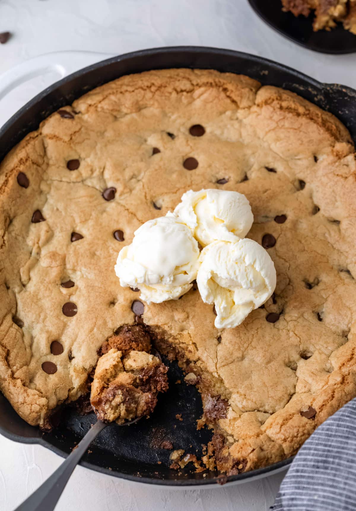 A spoon scooping out a piece of a pizookie. 