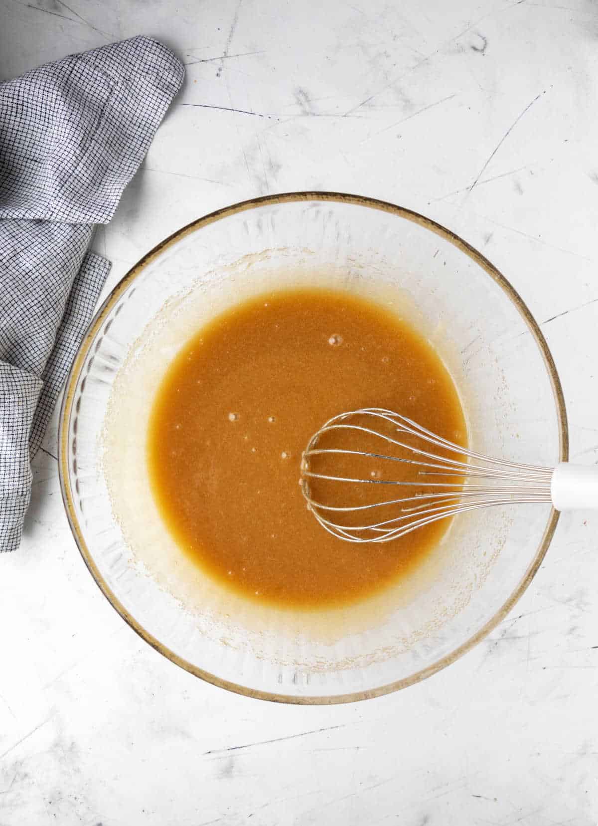 Melted butter and sugars whisked together in a bowl. 