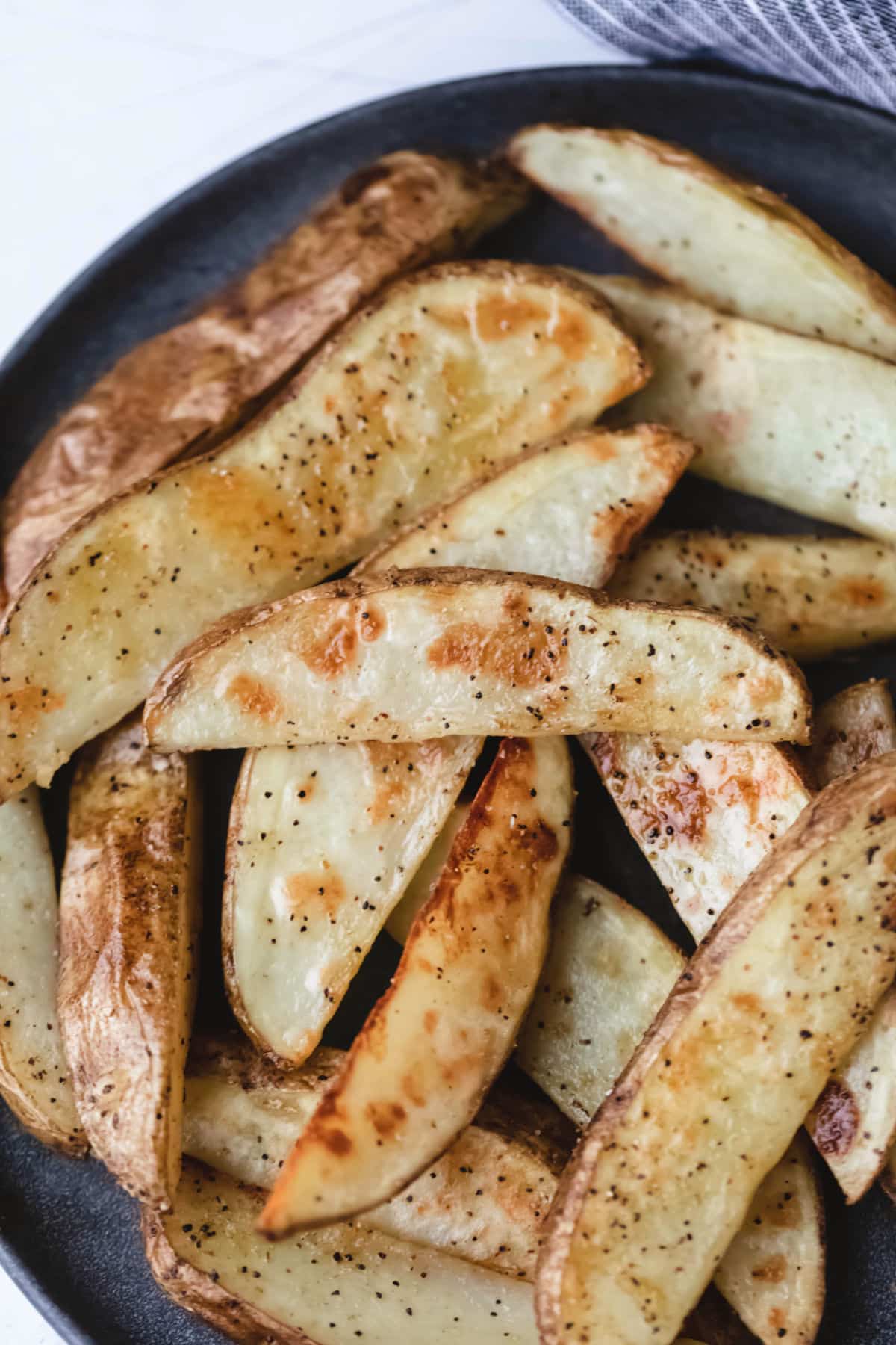 Close up photo of a heap of potato wedges. 