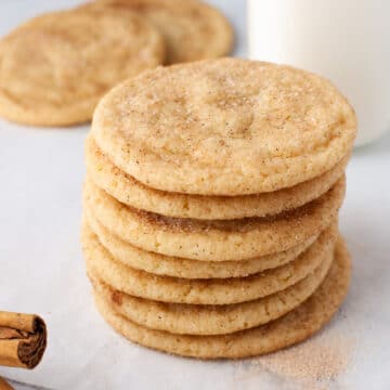 Stack of snickerdoodle cookies next to a bottle of milk.