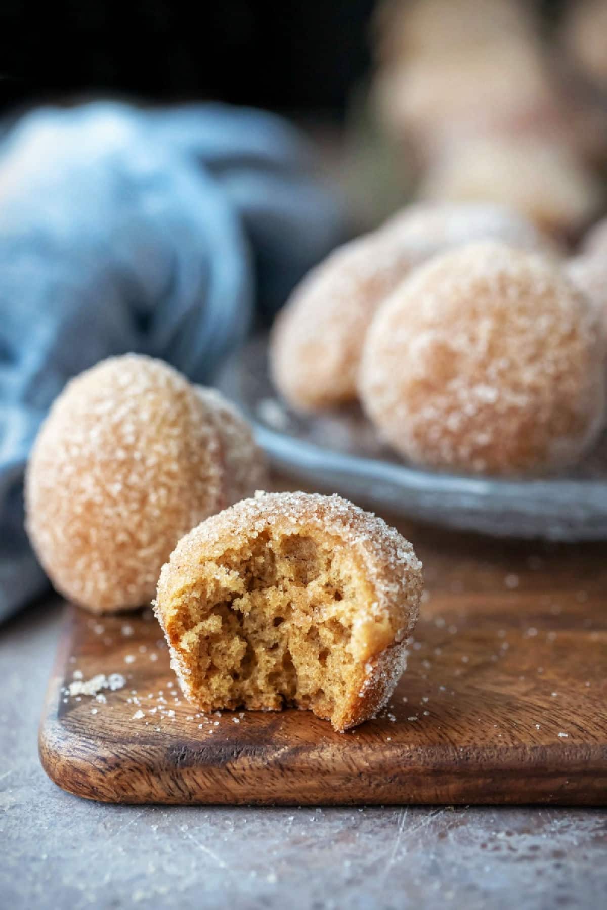 Apple Cider Donut Muffins Apple cider donut muffins on a wooden cutting board.