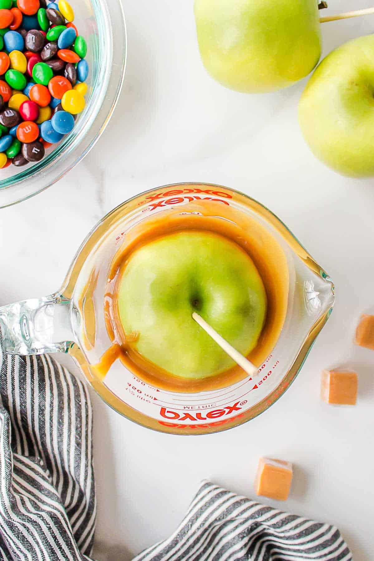 An apple in a cup of caramel.